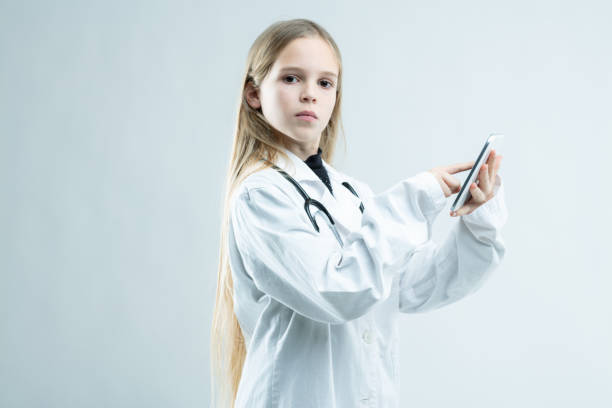 allvarlig ung flicka utklädd till läkare - nurse on phone serious bildbanksfoton och bilder