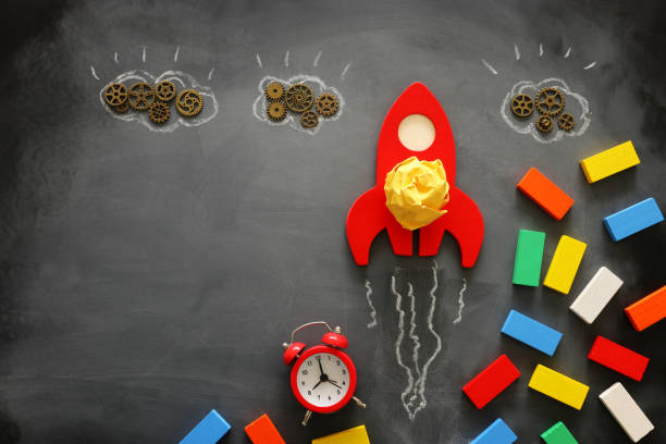 istock education or innovation concept. Wooden rocket over blackboard background. top view 1216723220