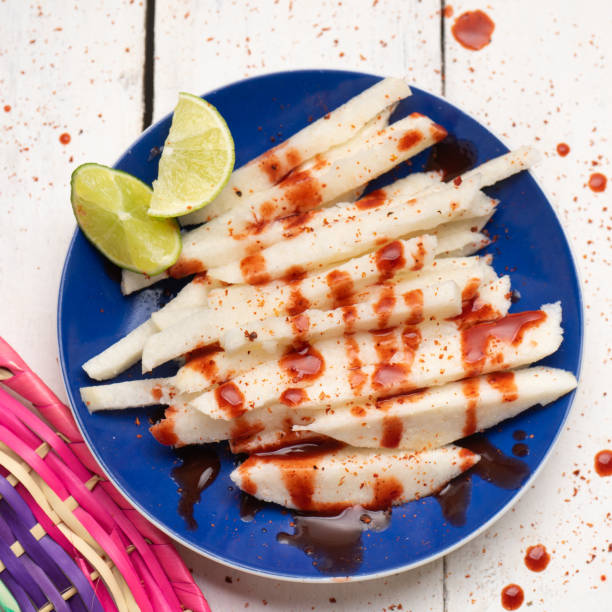 Mexican jicama cutted with chili powder and piquant sauce on white background Traditional mexican jicama cutted with chili powder and piquant sauce on white background pachyrhizus erosus stock pictures, royalty-free photos & images