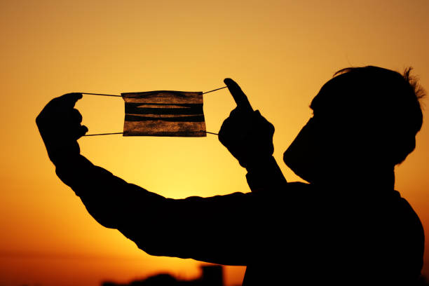 Silhouette of senior men holding pollution mask for protection from viruses stock photo