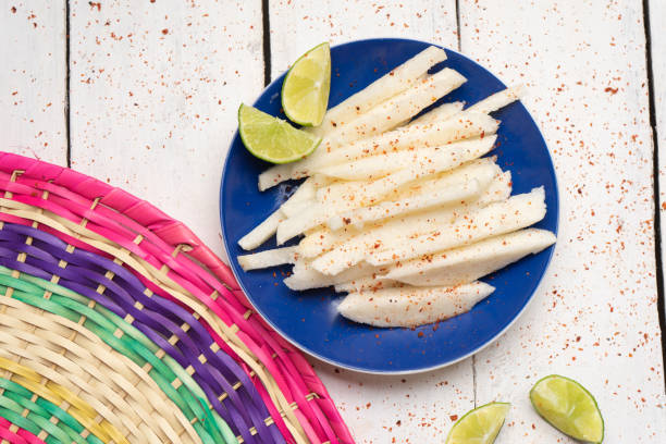 Mexican jicama cutted with chili powder on white background Traditional mexican jicama cutted with chili powder on white background pachyrhizus erosus stock pictures, royalty-free photos & images