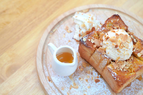 istock Honey toast topped with nuts and cups with honey on table 1216728803