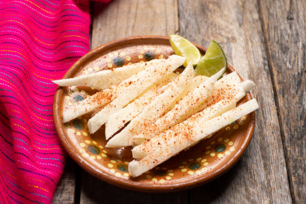 Mexican jicama cutted with chili powder on wooden background Traditional mexican jicama cutted with chili powder on wooden background pachyrhizus erosus stock pictures, royalty-free photos & images