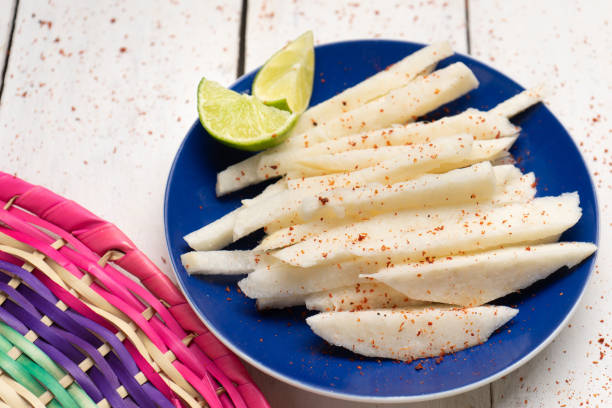 Mexican jicama cutted with chili powder on white background Traditional mexican jicama cutted with chili powder on white background pachyrhizus erosus stock pictures, royalty-free photos & images
