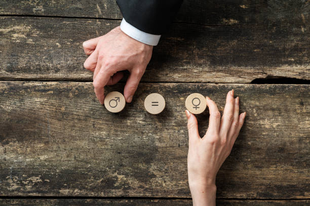 Gender equality conceptual image Gender equality conceptual image - male and female hand placing wooden cut circles with gender symbols over rustic wooden desk. gender equality stock pictures, royalty-free photos & images