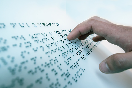 Hand of a blind person reading a text in the language of the blind, Braille