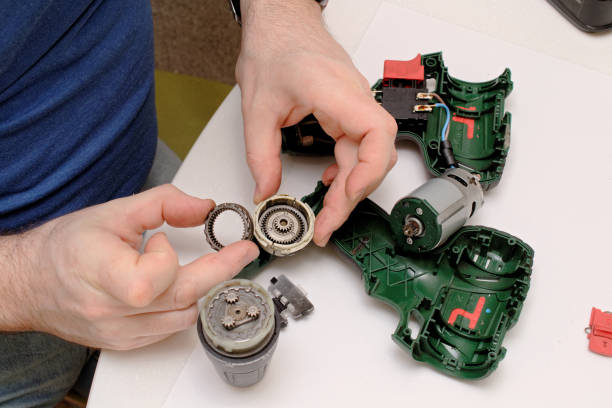 istock Engineer repairs a broken screwdriver. opens the case of the screwdriver. 1216736648