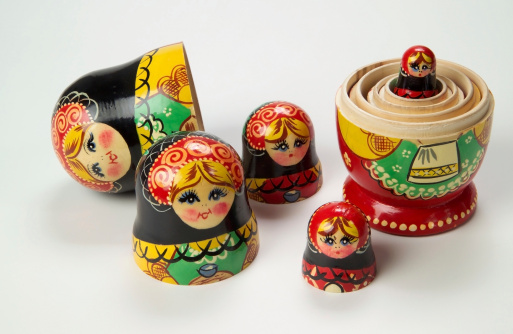 the matryoshka statuettes open on a yellow surface