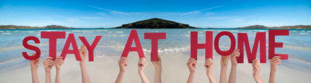 istock People Hands Holding Word Stay At Home, Ocean Background 1216737861