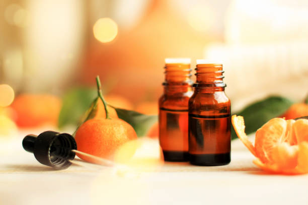aceite esencial de mandarina para la aromaterapia relajante y tratamiento de belleza, botellas goteros, cítricos, velas suaves luces de noche. - fruit winter orange lemon fotografías e imágenes de stock