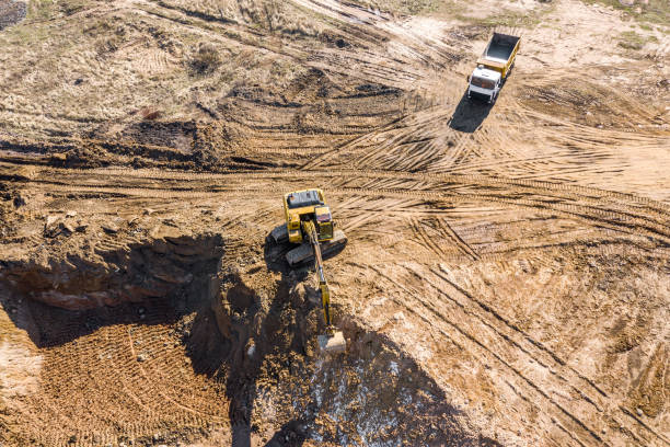 istock aerial view of excavator and trucks working at construction site 1216738841