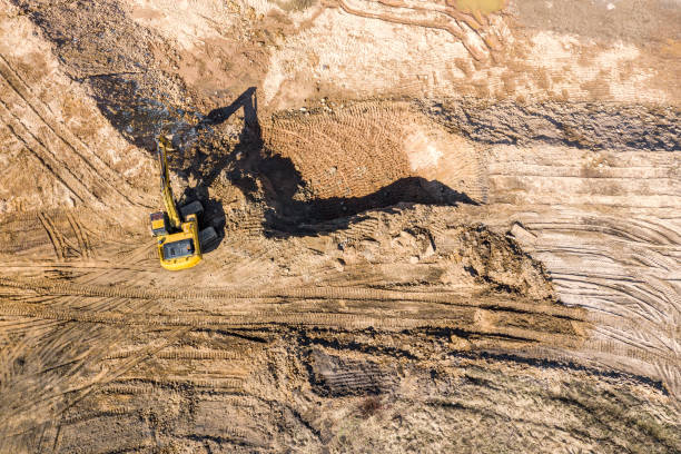 istock yellow industrial excavator doing earthmoving works at construction site. aerial view 1216738911