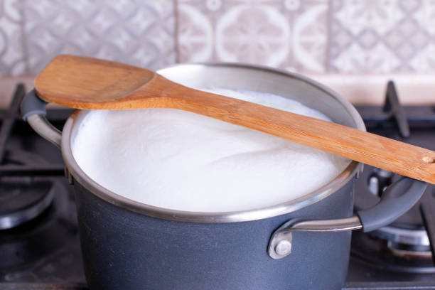 istock Boiling milk in a pan, wood spoon on the top 1216739428