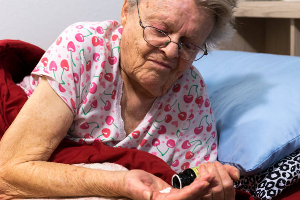 istock Sick senior woman takes pills 1216741898