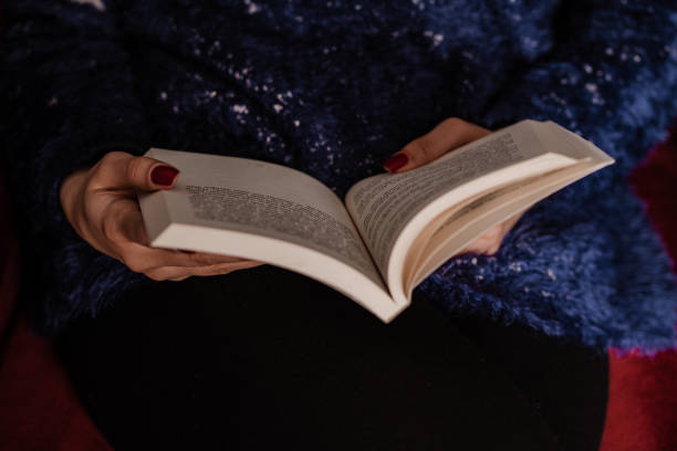 istock Young woman is reading book from home during quarantine time 1216743093