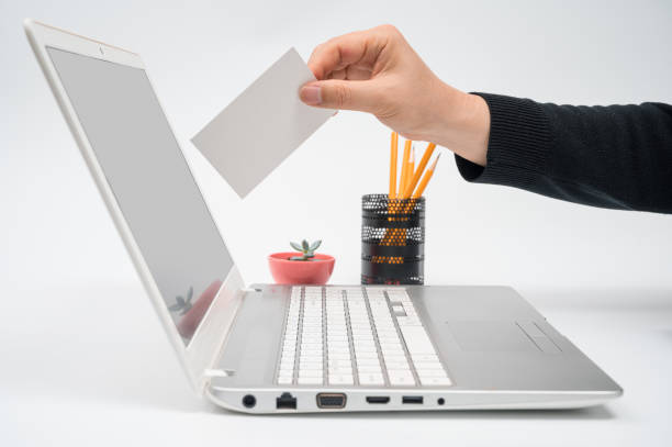 istock Online voting concept with a man with a ballot in hand putting a ballot toward the computer monitor. 1216744657
