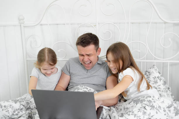 istock kids interfere freelancer work in isolation in bed 1216747538