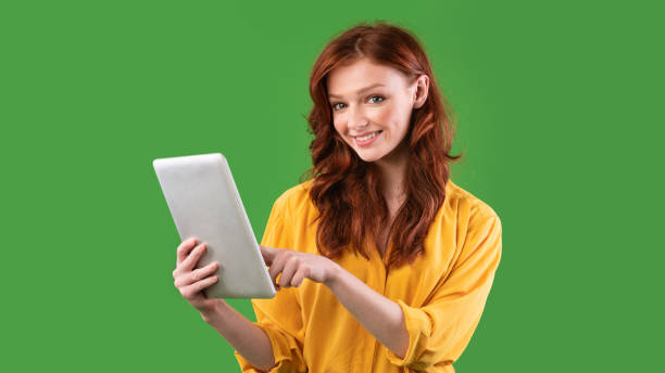istock Student Girl Using Digital Tablet On Green Studio Background, Panorama 1216748419