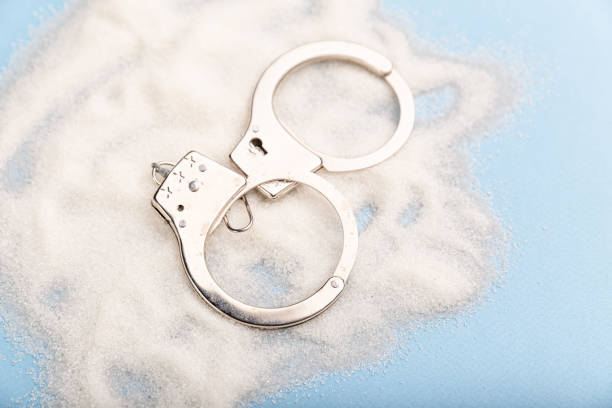 Sugar is dangerous. Handcuffs on the table. Sweet dependence.