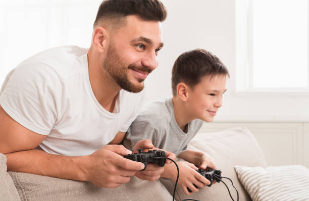 istock Self-isolated dad and son playing video games at home 1216749682