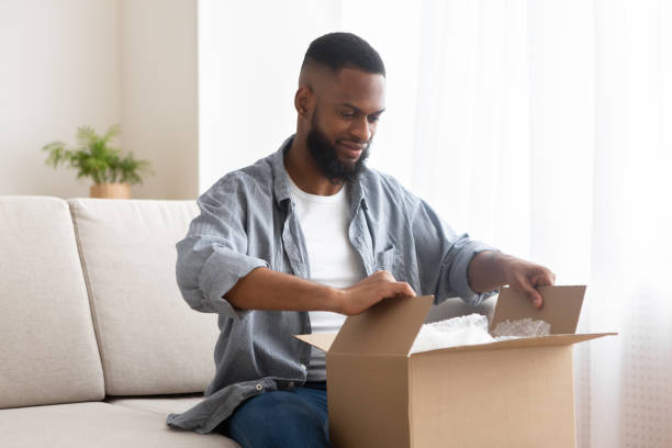 istock Male buyer unpack cardboard box at home 1216749852