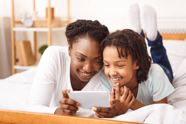 istock Black mother watching cartoons with her daughter 1216750006