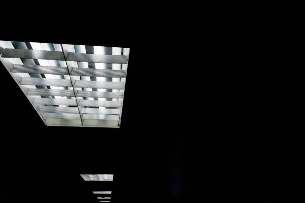 istock The fluorescent lamp on the ceiling. The background is black. 1216750211