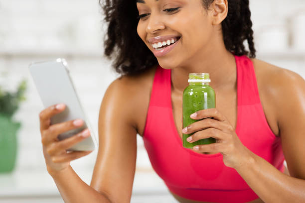 istock Black Girl Drinking Smoothie And Using Phone 1216751225