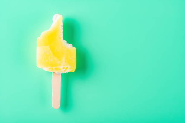 istock mostly eaten yellow popsicle on a light green background 1216752614