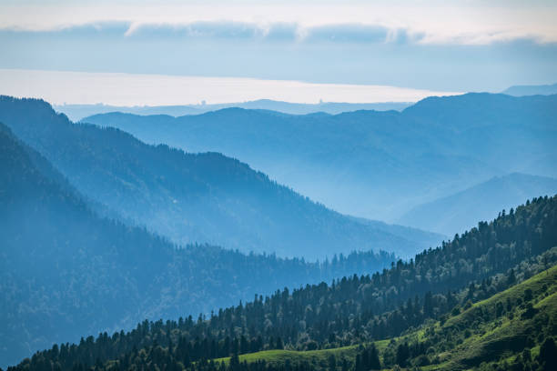 istock View over the Green Valley, surrounded by high mountains on a summer sunset. Layers of mountains in the haze during sunset. 1216752904