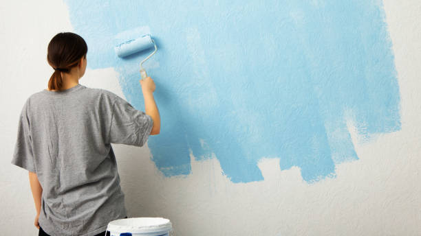 istock Woman paint wall at home, free space 1216755571
