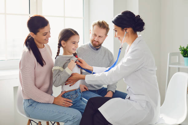 Happy family on a visit to the doctor in the office of a doctor. stock photo