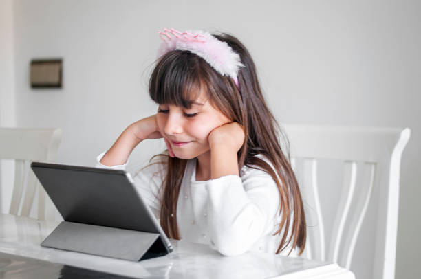 istock Littel girl using digital tablet at home 1216759432