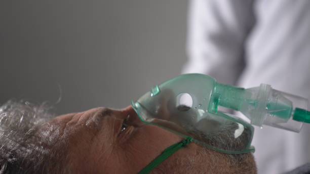 An old man infected by coronavirus is receiving ventilation in intensive care unit . An old man infected by coronavirus is receiving ventilation in intensive care unit . medical ventilator photos stock pictures, royalty-free photos & images