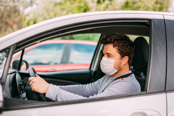 istock Man Wearing a Sterile Mask Driving a Car 1216760438