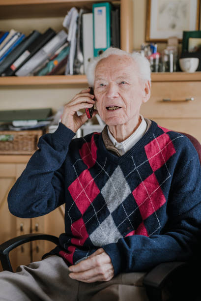 istock Elderly man talking on phone sitting at home 1216761716
