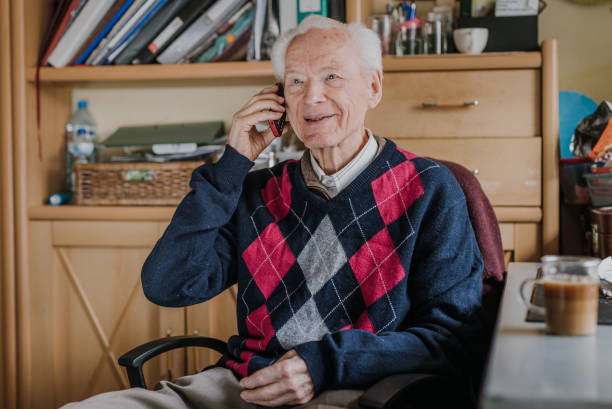 istock Elderly man talking on phone sitting at home 1216761730