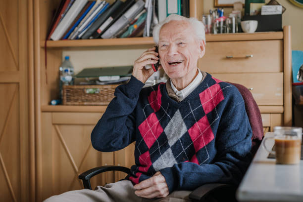 istock Elderly man talking on phone sitting at home 1216761750