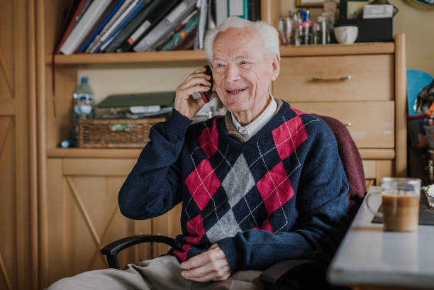 istock Elderly man talking on phone sitting at home 1216761763