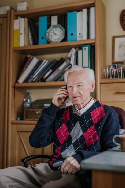 istock Elderly man talking on phone sitting at home 1216761777