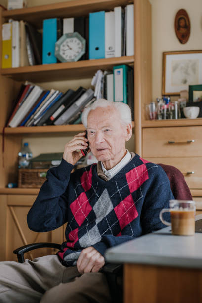 istock Elderly man talking on phone sitting at home 1216761788