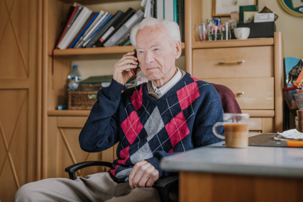 istock Elderly man talking on phone sitting at home 1216761796