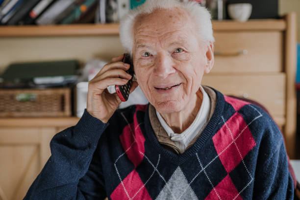 istock Elderly man talking on phone sitting at home 1216761817