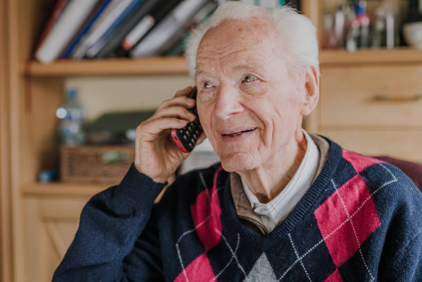 istock Elderly man talking on phone sitting at home 1216761826