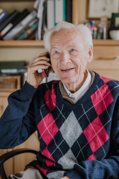 istock Elderly man talking on phone sitting at home 1216761843