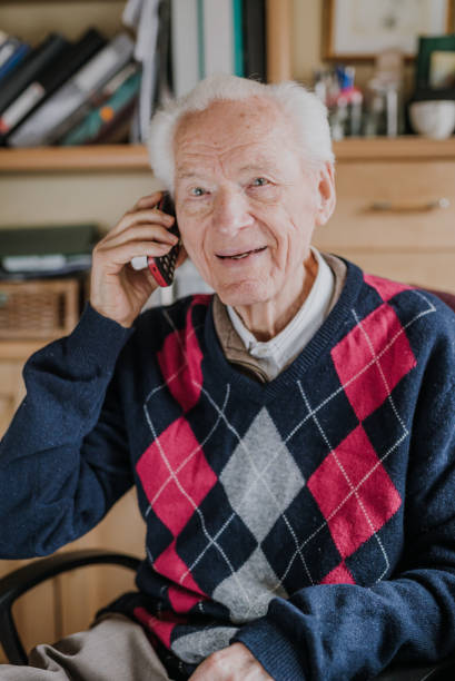 istock Elderly man talking on phone sitting at home 1216761856