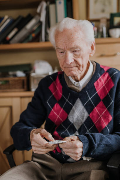 istock Old man holding medicine blister in hands 1216761973