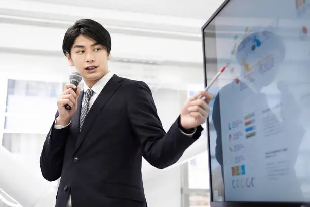 A Japanese male businessman giving a presentation.