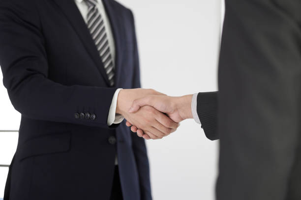 A Japanese male businessman A Japanese male businessman shakes the hand of a contract talking two people business talk business stock pictures, royalty-free photos & images