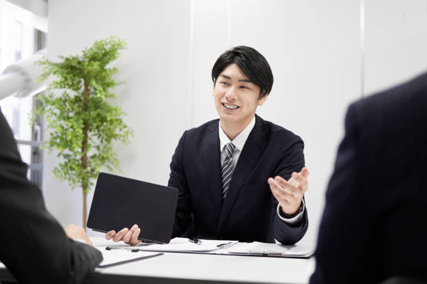 Japanese male businessmen Japanese male businessmen explaining face-to-face. door to door salesperson photos stock pictures, royalty-free photos & images